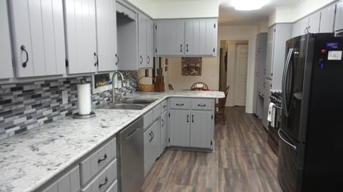 Kitchen from garage door looking towards dinette and entry hall.
