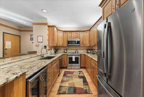 Full kitchen featuring stainless steel appliances, including a wine fridge.