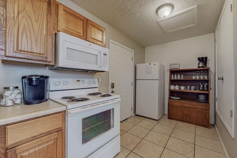 This kitchen has a full stove, microwave, refrigerator, and sink