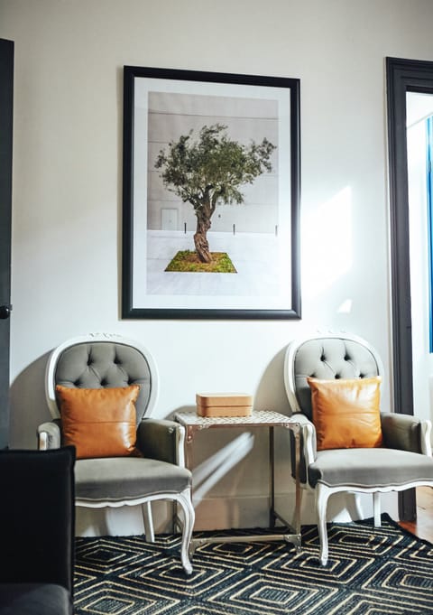 Vintage Louis Philippe armchairs and above the olive tree, symbol of peace and friendship coming from the times of ancient Greece