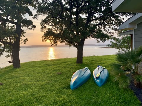 Sunrise at Buchanan Lake from the property. Your getaway includes a main house, guest house, BBQ smoke house, and accommodates up to 10 people. Two kayaks, inflatables, and other lawn games are included for your enjoyment!