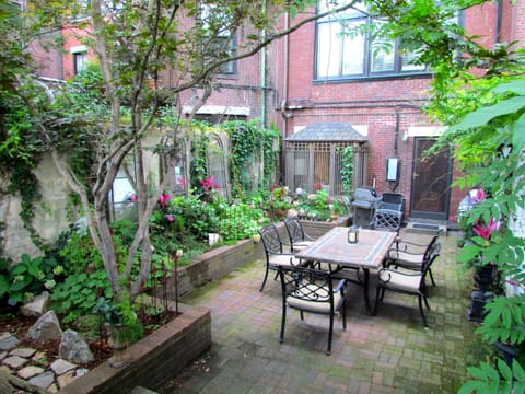 Private landscaped patio with dining table, bistro table and grill