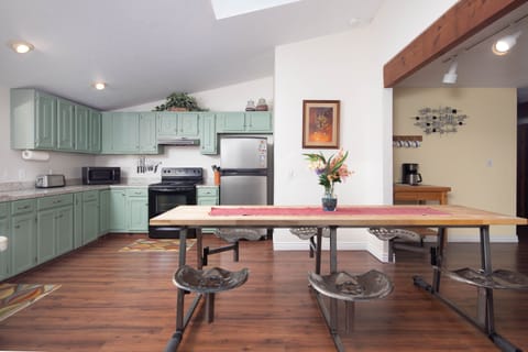 Kitchen area with 6 person butcher block table. Seats are adjustable