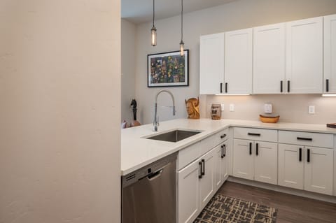 Washer and modern sink with a clean and spacious granite counter top.