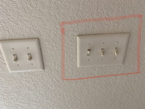 Switch next to sliding door. DO NOT touch switch in red, controls the curtain 