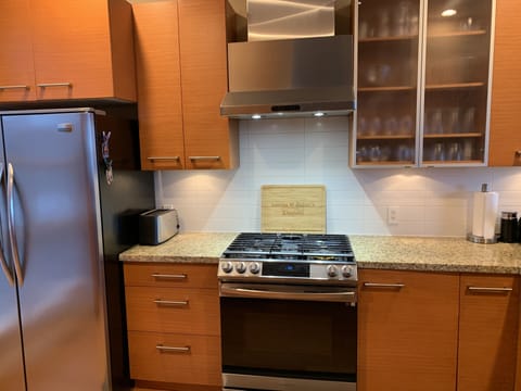 New Samsung gas range with stylish exhaust hood.