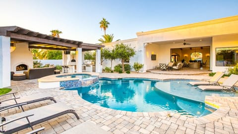 Sparkling pool, spa, & sun loungers w/ panoramic doors to living room.