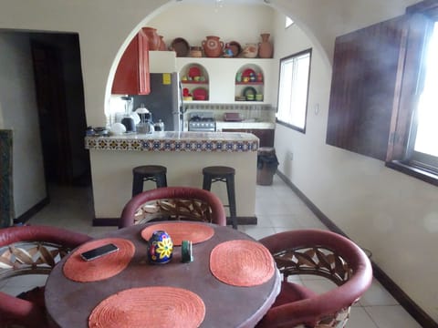 Dining table and bar with stools,  looking into the kitchen