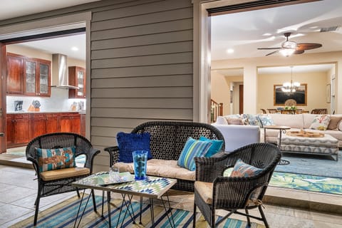 Wicker furniture on the lanai with a view inside the home.