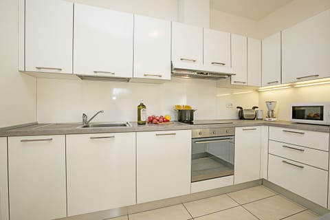 The fully equipped kitchen  with dishwasher, oven, cooker hob and Microwave