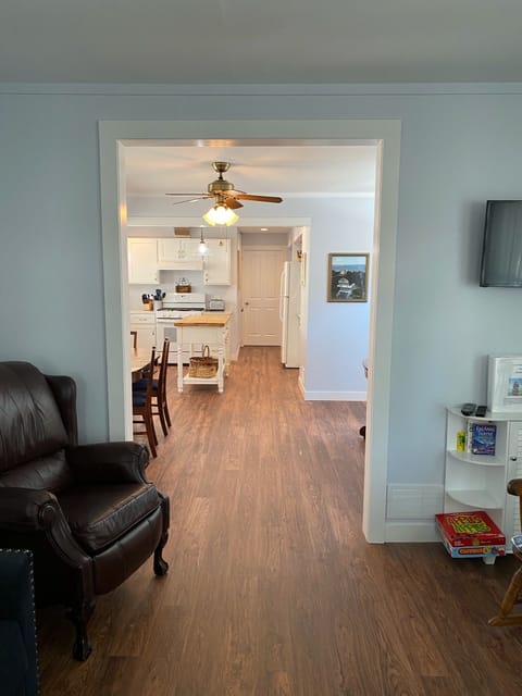 View from front door of living & dining rooms and kitchen; wall mounted TV.