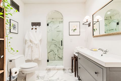 Calacatta marble bathroom welcomes you with arch top shower entry