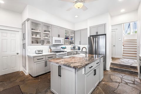 Bright and airy kitchen layout with stainless steel appliances and custom finishes.