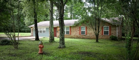 Front view of home, shade trees, creek, located in secluded area.