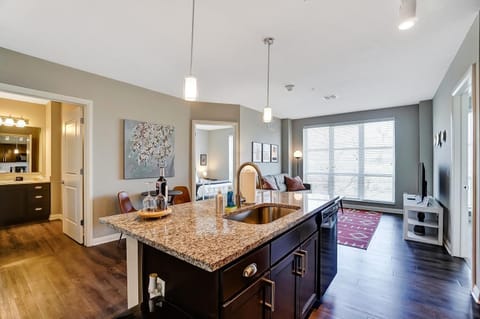 Wide angle view of the kitchen island and open concept living area! Beautiful and modern.