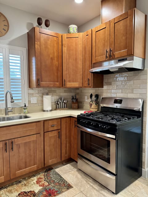 Gas stove, large kitchen sink, garbage disposal, high-arc faucet.