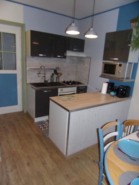 La cuisine: cafetière filtre, bouilloire, grille-pain, four, réfrigérateur.