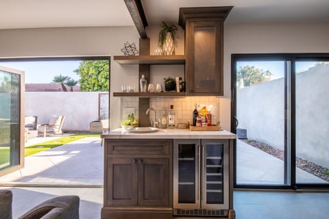 The wet bar equipped with a dual zone beverage fridge-patio access on each side