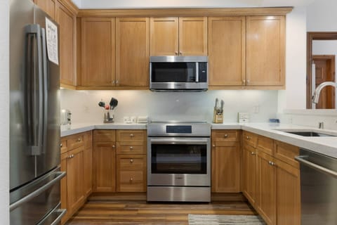 Kitchen features electric range, microwave, dishwasher, refrigerator with ice maker.