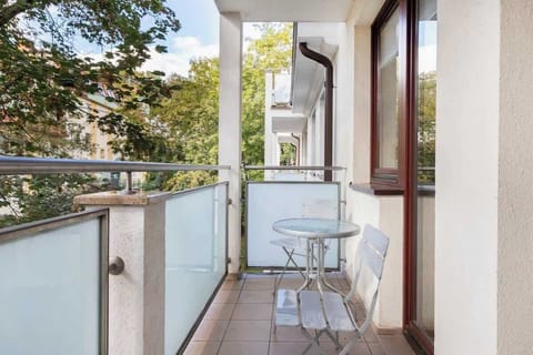 Furnished balcony with green surroundings. 
