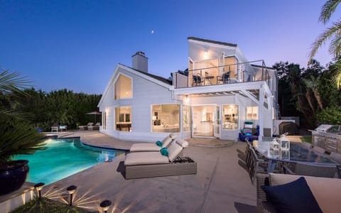 Stunning view of the house from the patio with pool, hot tub, BBQ, and seating