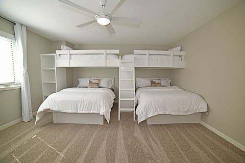 Upper level bunk bedroom with two full-size beds and two twin beds.