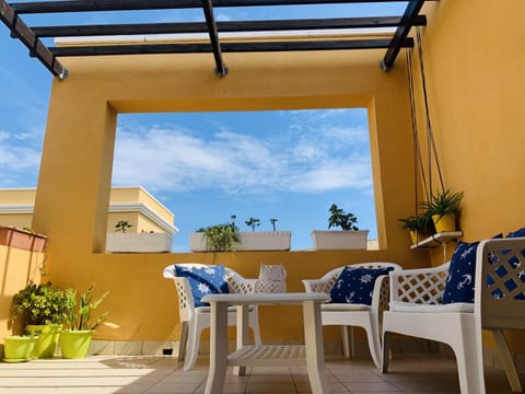 Upstairs Terrace with flowers and comfy chairs.