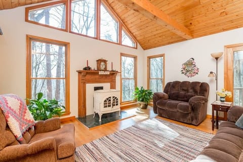 Stunning living room with wood accent and fireplace. Wooded views abound.