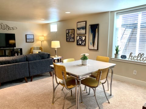A bright light-filled basement guest suite with retro seating for 4.