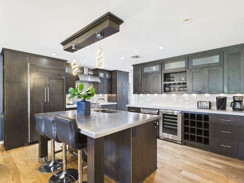 Fully equipped kitchen with stainless steal appliances and a kitchen island with bar seating for 3 guests.