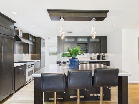 Fully equipped kitchen with stainless steal appliances and a kitchen island with bar seating for 3 guests.