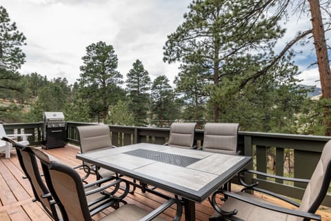 Outdoor dining space with BBQ grill and mountain views.