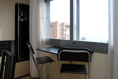 Breakfast or work nook maximizing natural light and exterior views. Compact arrangement with a fold-down table and folding chairs, ideal for optimizing small spaces.