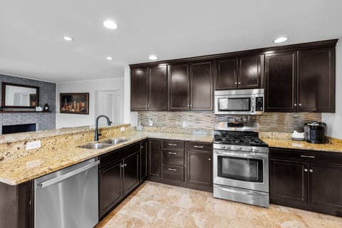 Fully equipped kitchen with stainless steel appliances and seating for 3 people and a bar with 4 stools