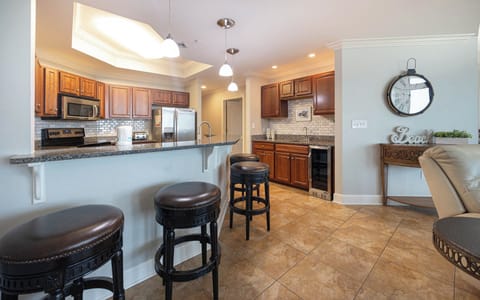 This modern kitchen features stainless appliances, granite countertops, and a stylish wet bar for a delightful experience