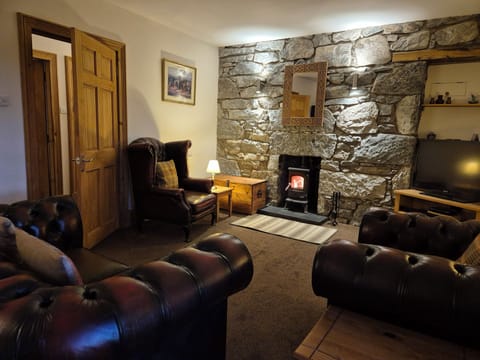 Very spacious living room, chesterfield suite, granite stone wall & woodburner.