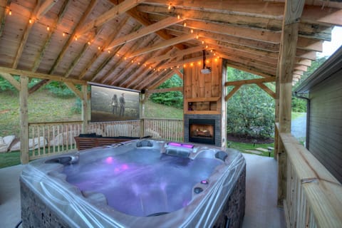 luxurious hot tub in front of wood burning fireplace & 110 inch movie projector