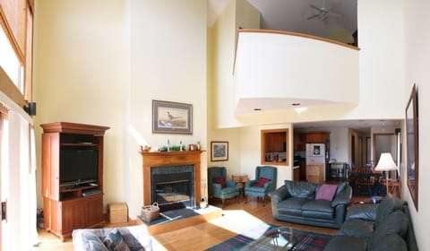 Spacious open living area with flat screen TV and wood burning fireplace