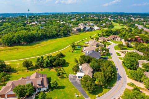 Aerial view of neighborhood shows lush greenery and mature trees