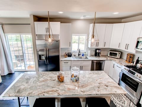 Spacious Kitchen with natural Quartzite countertops and new SS appliances.