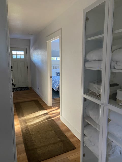 Hallway closet with extra towels, robes, slippers, and other helpful extras