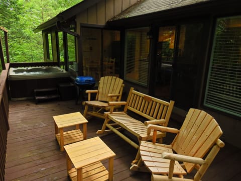 back deck with rocking chairs, grill, and hot tub