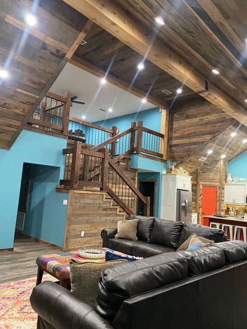 Living room with view of loft that leads to bunkroom and bathroom 