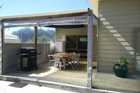 Outdoor BBQ Area with large table, beer fridge and hooded BBQ.