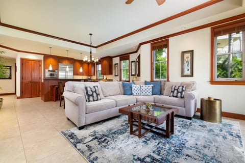 Spacious living room with plush sectional sofa - Open layout connects to modern kitchen and dining area,