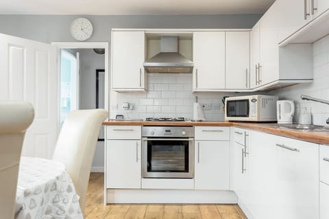 kitchen area showing oven, microwave, dishwasher and dining table and chairs