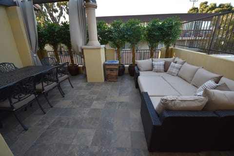 Large raised outdoor patio with double fire pit table and lounging area.