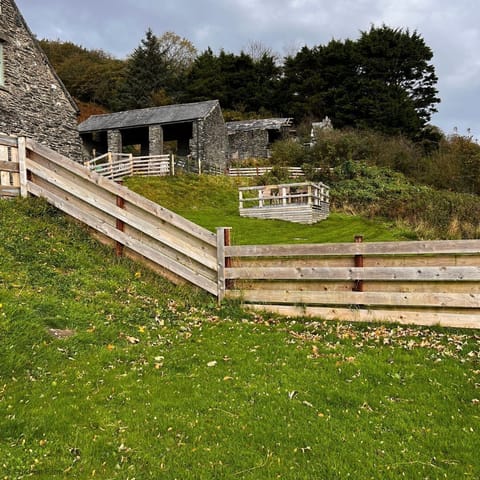 Fence line shared with The Barn . Fences are mix of wooden boards and wire stock fencing.