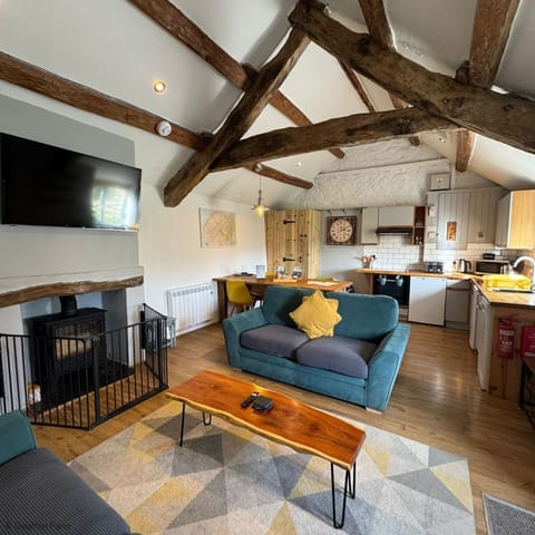 Open plan living space with log burner at The Cowshed