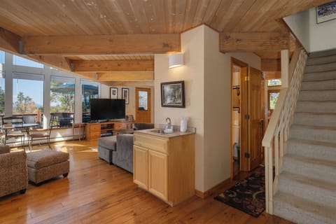 Small hand sink located next to the living area, a powder room in the central hallway, and a staircase leading up to the secondary master.